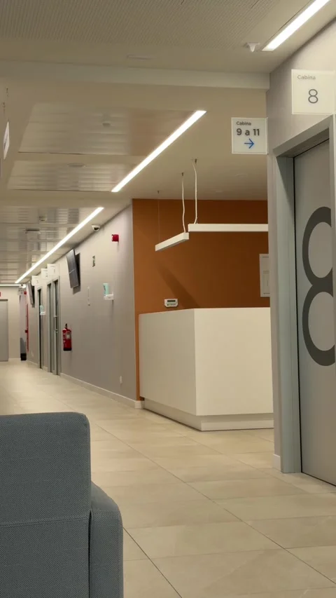 Hospital lobby corridor featuring reception counter, numbered doors Video stock 336733773
