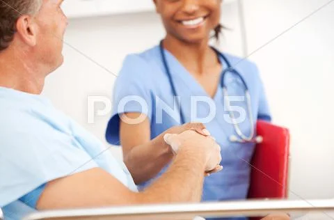 Hospital: nurse and patient shake hands Stock Photos