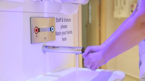 Hospital worker using a hand washing station at a UK NHS hospital Stock Footage 65730436