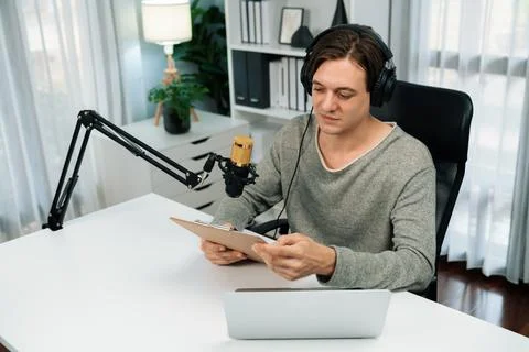 Host channel in broadcaster with script note reading to listeners. Pecuniary. Stock Photos