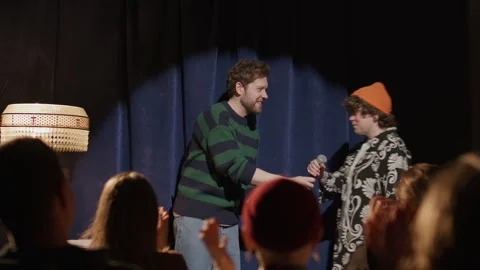 Host Introducing Female Standup Performer at Comedy Event Stock Footage 333228057