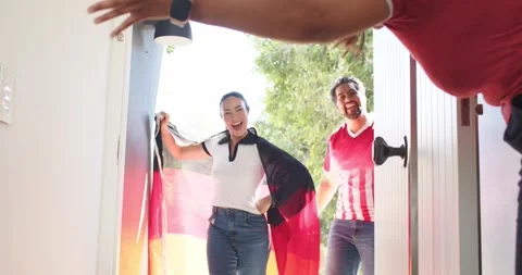 Host opening front door, welcoming Asian woman and African American man entering Vidéo 341468658