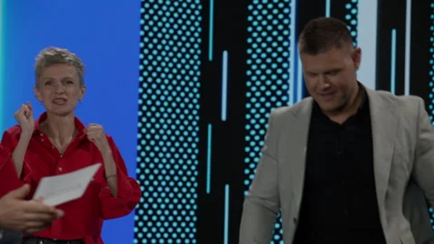 Host talking to contestants during recording of a fictional morning game show Stock Footage 259794727