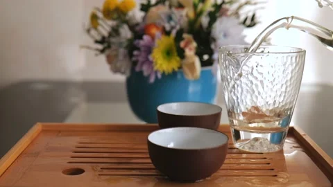 The host of the tea ceremony pours brewed white tea into a glass flask. 4k Stock Footage 220342013