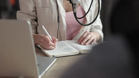 Host write note during recording podcast, make lyrics text script in notebook Video stock 156527445