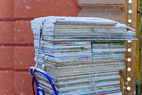 Hostas with paintings lie in a stack in a cart under the snow Stock Photos