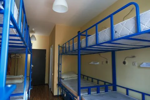 Hostel dormitory beds arranged in dorm room Stock Photos
