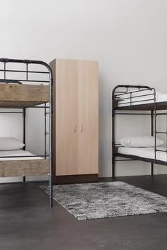 This hostel room features two sets of metal bunk beds placed against the wa.. Stock Illustration