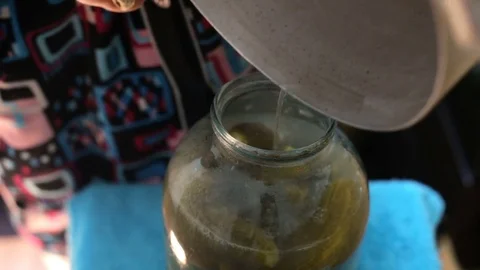 The hostess closes the cucumbers in the cans Stock Footage 77781959