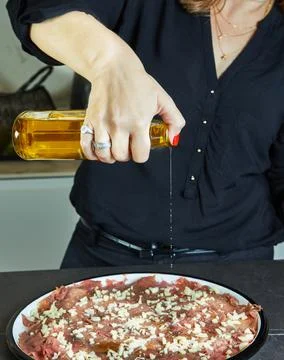 Hostess making carpaccio on marble kitchen countertop with her hands Stock Photos