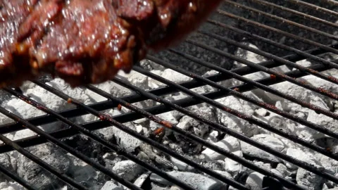 Hostess turns steak using tongs on the grill grate Stock Footage 104626736