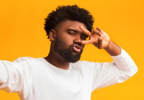 Hot afro guy holding camera and making selfie Photos