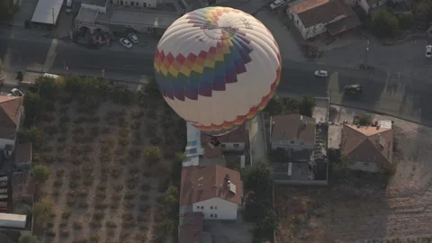 Hot air balloon with designed envelope flies over buildings Video stock 150137980