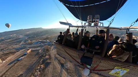 A hot air balloon, filled with people, floats above the landscape of Cappadocia Video stock 265561353