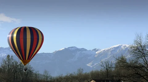 Hot air balloon in flight over mountains Stock Footage 31287730