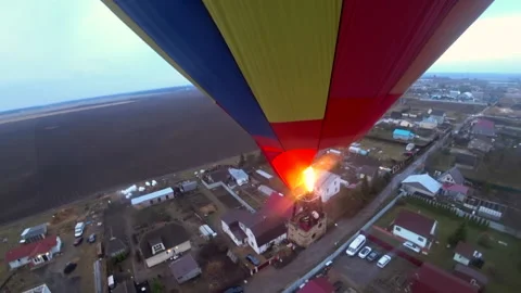 Hot air balloon flight over a small village with cottages Stock-Footage 155530293