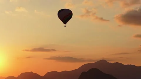 Hot Air Balloon Floating over Tropical Mountains at Golden Sunset Stockbeeldmateriaal 330816639