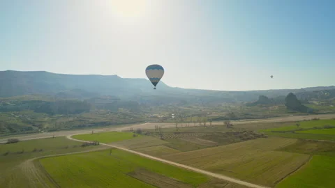 Hot air balloon flying over green grass in cappadocia drone shot 4k Stock Footage 254775160