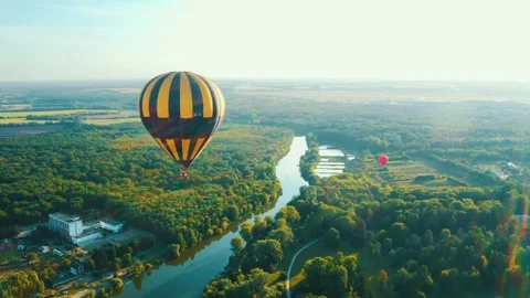 Hot Air Balloon Flying Over Scenic River and Lush Forest Landscape Video stock 344352905