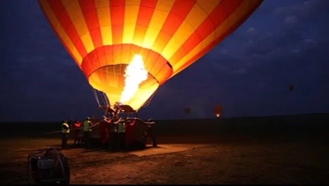 Hot Air Balloon Illuminates When Being Filled at Dawn in the Masai Mara  (HD) Stock Footage 8599424