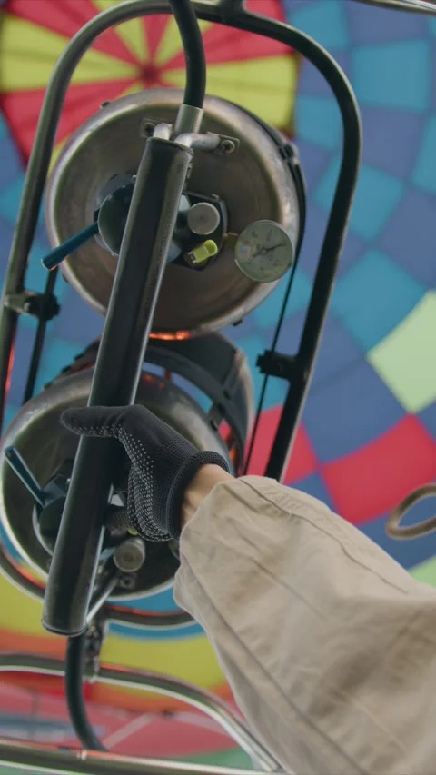 Hot air balloon inflation process with operator turning valve on mechanical Stock Footage 348244875