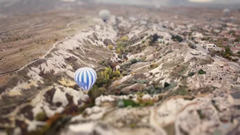 Hot air balloon is levitating over Cappadocia valleys filmed by drone with tilt Stock Footage 344045109