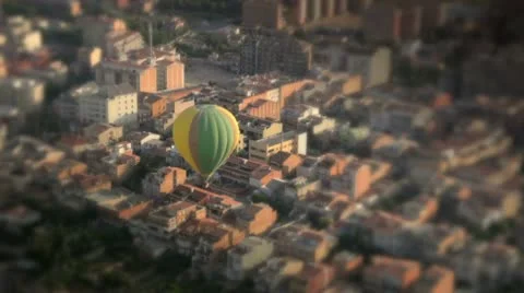 Hot air balloon passing over a city shift and tilt Stock Footage 9100982