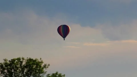 Hot Air balloon in rainbow pattern lifts towards left and fades in early mor Video stock 133014528