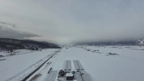 Hot Air Balloon Shadow Drifting Over Snowy Greenhouses in Furano Japan Stock Footage 334454786