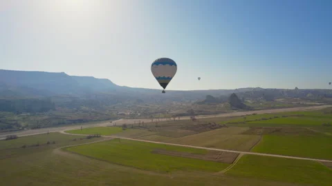 A hot air balloon takes off in front of other balloons. Drone Shot 4K Stock Footage 254775874