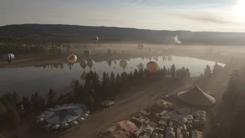 Hot air balloons hovering over festival near camping area Stock Footage 105467640