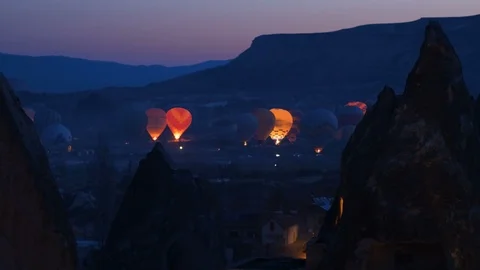 Hot air baloons preparing for take off. Famous sightseeing Cappadocia. Lights of Stock Footage 105676647
