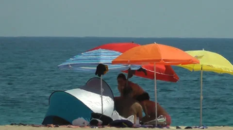 Hot beach day under brightly Colored Beach Umbrellas Stock Footage 33171579