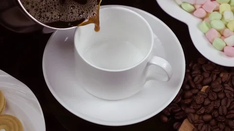 Hot Black coffee is poured into a white cup. Slow motion. Stock Footage 79050514