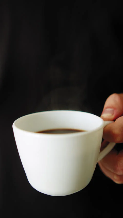 Hot black coffee with steam. Vertical lifestyle video of a Man holding a cu.. Stock-Footage 337127128