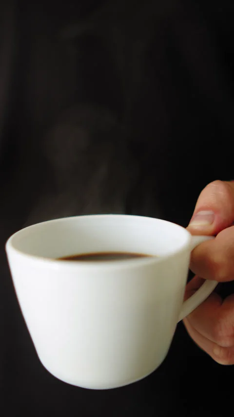 Hot black coffee with steam. Vertical lifestyle video of a Man holding a cu.. Stock Footage 337127175