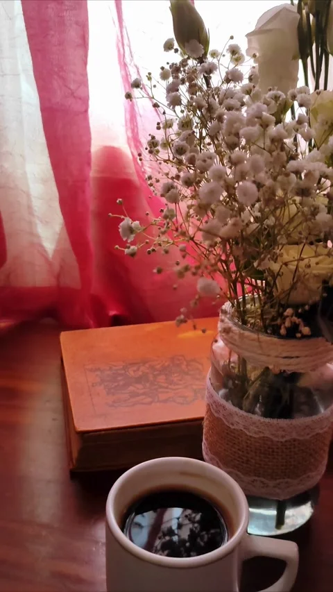Hot black coffee on table with book and flowers Stock Footage 331974437