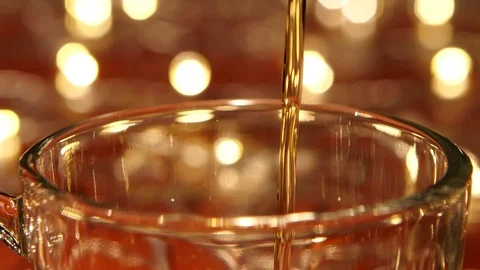 Hot black tea being poured into glass transparent cup, closeups Stock Footage 73634283