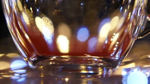 Hot black tea being poured into glass cup. Slow motion Stock Footage 73635935