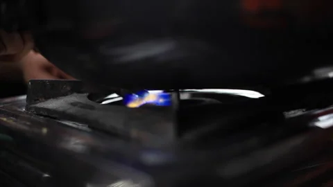Hot blue flame came out whenThe chef switch on the stove with a lighter Stock Footage 154307639