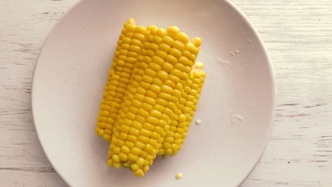 Hot, boiled corn sprinkled with salt. Stock Footage 134705705