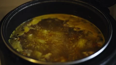 Hot boiling soup with vegetables inside dark metal cooking pot Stock-Footage 338023278
