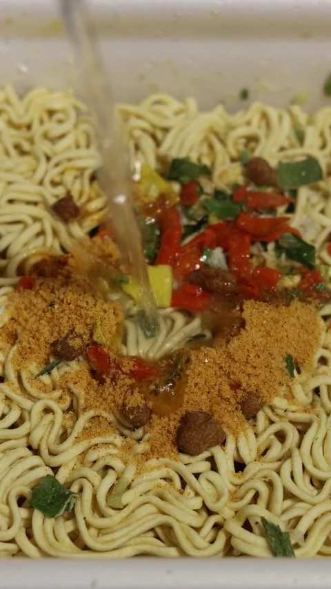 Hot boiling water poured in white plastic plate bowl with ramen Stock Footage 343683849