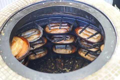 Hot bread is baking inside a traditional oven in a busy kitchen setting Stock Photos