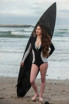 Hot brunette standing in front of her board. Stock Photos