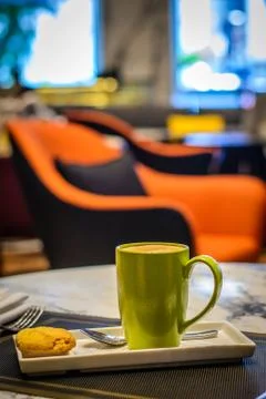 Hot cafe latte with cookie on the side and a steel tea spoon Stock Photos