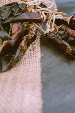 Hot chilli pepper on black background with rustic cloth, vintage tablecloth.  Stock Photos