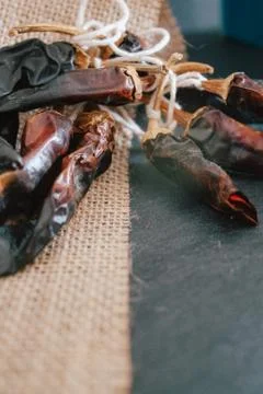 Hot chilli pepper on black background with rustic cloth, vintage tablecloth.  Stock Photos