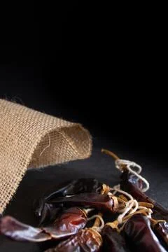 Hot chilli pepper on black background with rustic cloth, vintage tablecloth.  Stock Photos