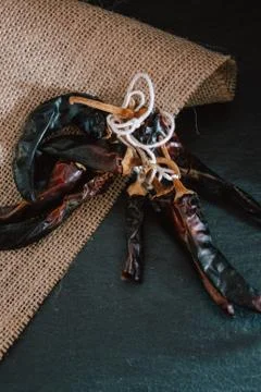 Hot chilli pepper on black background with rustic cloth, vintage tablecloth.  Stock Photos